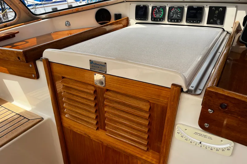 Slide: The Image of Interior of a 1997 Hallberg-Rassy 42F sailboat, featuring wooden cabinetry and instrument panel. - 50