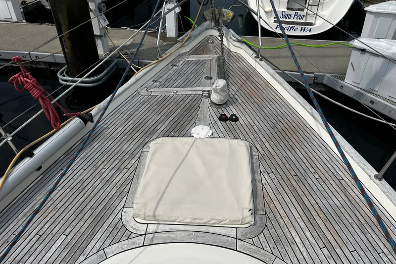 Slide: The Image of Deck of 1997 Hallberg-Rassy 42F sailboat, featuring teak wood and mooring lines. - 42