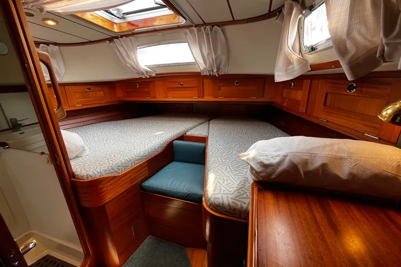 Slide: The Image of Luxurious 1997 Hallberg-Rassy 42F yacht cabin with cozy bedding and elegant wood finish. - 15
