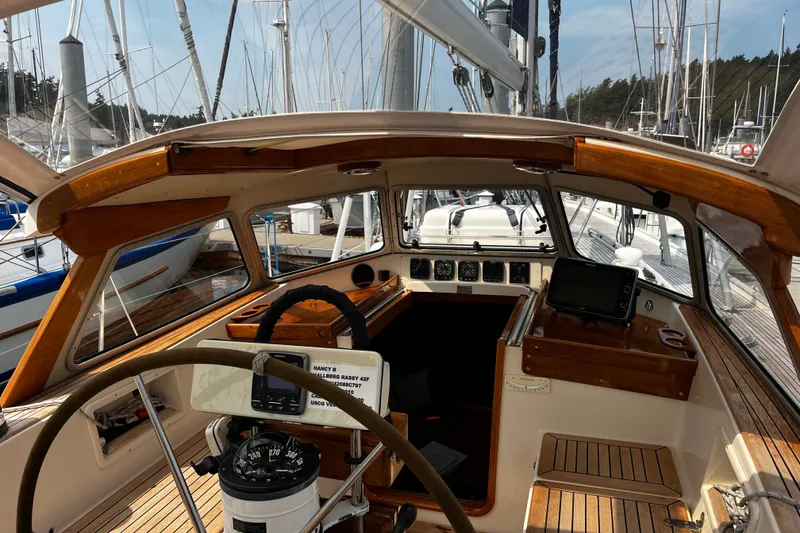 Slide: The Image of Cockpit of 1997 Hallberg-Rassy 42F sailboat with wooden accents and navigation equipment. - 58