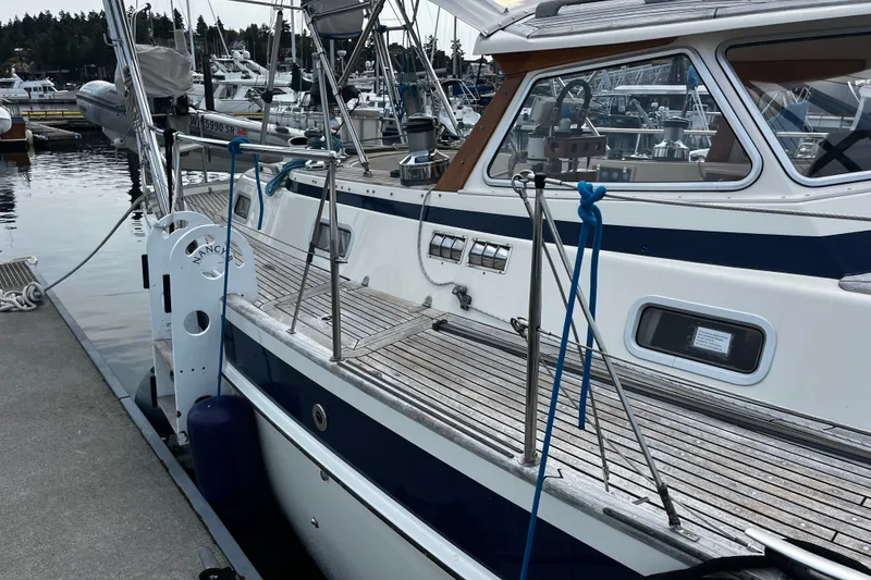 Slide: The Image of Sailboat docked at marina, Hallberg-Rassy 42F, 1997 model, featuring teak deck and blue accents. - 73