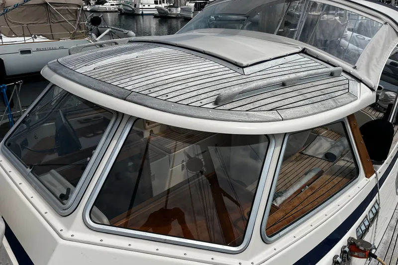 Slide: The Image of 1997 Hallberg-Rassy 42F yacht with wooden deck and sleek design in marina setting. - 48