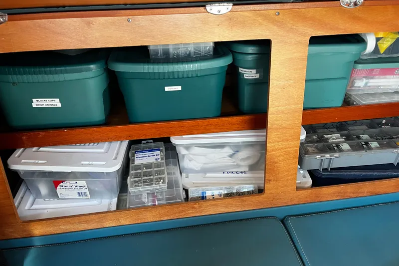 Slide: The Image of Storage compartments with labeled containers inside a 1997 Hallberg-Rassy 42F yacht. - 28