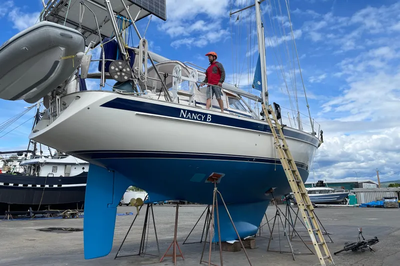 Slide: The Image of Sailboat Hallberg-Rassy 42F, 1997 model, on dry dock with a person standing on deck. - 95