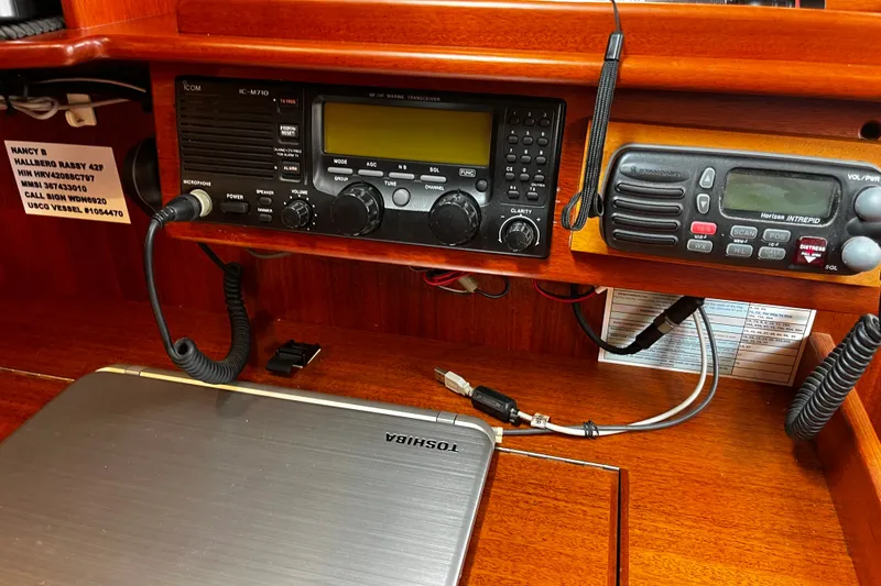Slide: The Image of Radio equipment and laptop on a 1997 Hallberg-Rassy 42F yacht's wooden navigation station. - 25