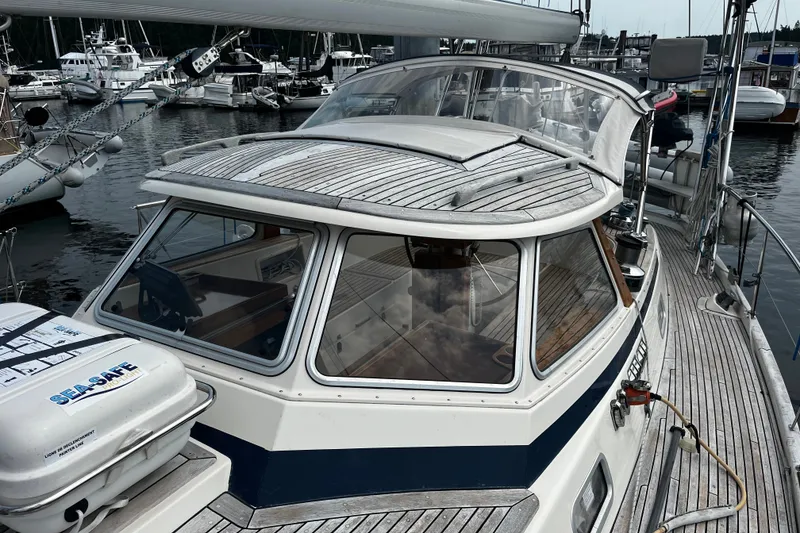 Slide: The Image of 1997 Hallberg-Rassy 42F sailboat docked at marina, showcasing sleek design and wooden deck. - 66