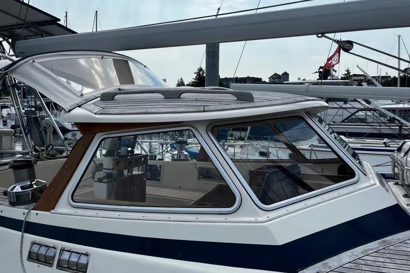 Slide: The Image of 1997 Hallberg-Rassy 42F yacht docked at marina, showcasing cockpit and deck details. - 74