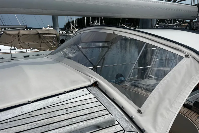 Slide: The Image of 1997 Hallberg-Rassy 42F sailboat with covered cockpit and visible marina background. - 49