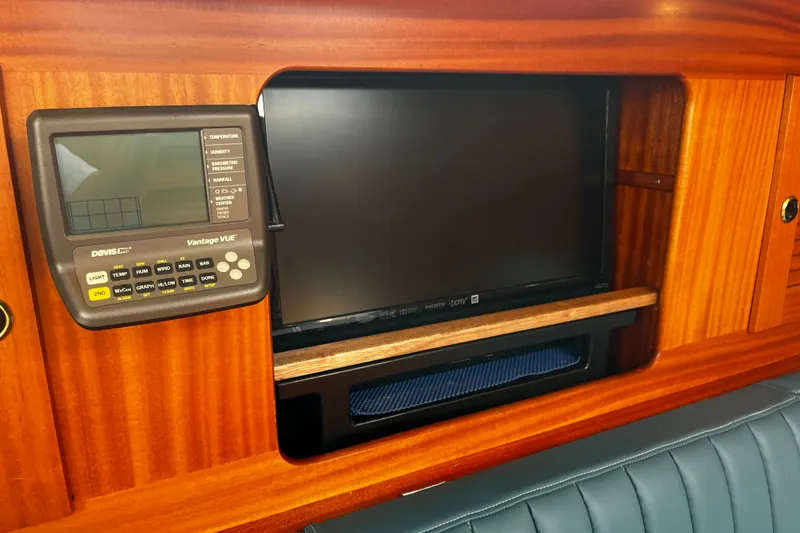 Slide: The Image of Weather station and TV in 1997 Hallberg-Rassy 42F yacht interior, featuring wood paneling. - 29