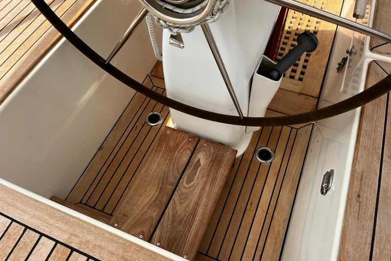 Slide: The Image of Cockpit of 1997 Hallberg-Rassy 42F sailboat with wooden flooring and steering wheel. - 54