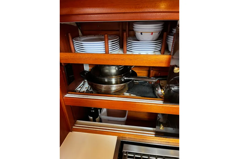 Slide: The Image of Galley storage in 1997 Hallberg-Rassy 42F yacht with dishes and cookware neatly organized. - 20
