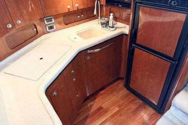 Slide: The Image of 2004 Sea Ray 390 Motor Yacht kitchen with wood cabinetry and compact appliances. - 22