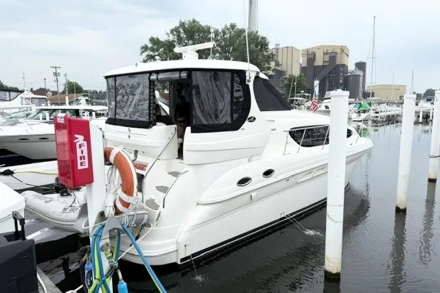 Slide: The Image of 2004 Sea Ray 390 Motor Yacht docked at marina, featuring sleek white design. - 1