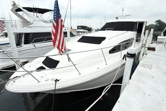 The Image of 2004 Sea Ray 390 Motor Yacht docked, featuring sleek design and American flag. - 0