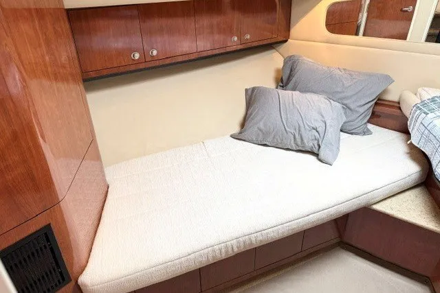 Slide: The Image of 2004 Sea Ray 390 Motor Yacht cabin with wooden cabinetry and cozy bedding. - 29