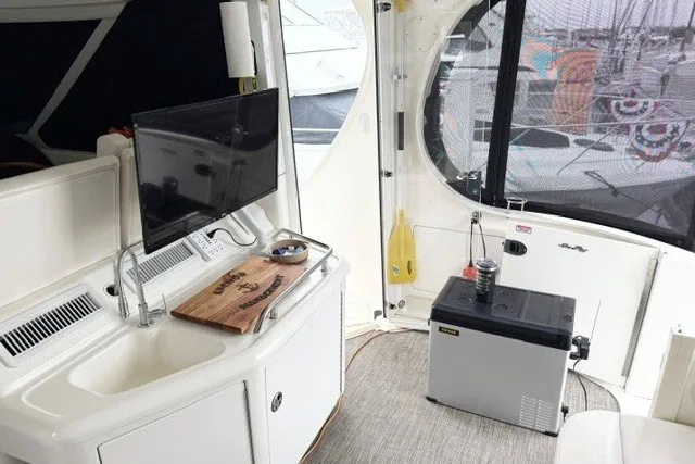 Slide: The Image of Interior of 2004 Sea Ray 390 Motor Yacht with sink, TV, and mini fridge. - 6