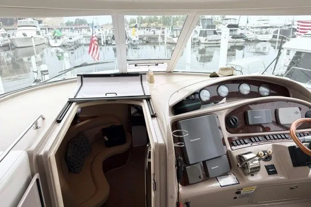 Slide: The Image of 2004 Sea Ray 390 Motor Yacht helm with navigation equipment, overlooking marina with docked boats. - 36