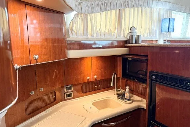 Slide: The Image of Luxurious 2004 Sea Ray 390 Motor Yacht kitchen with wood cabinetry and modern appliances. - 23