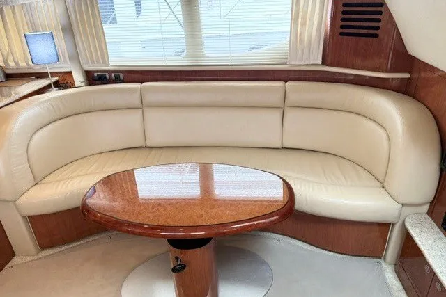 Slide: The Image of Luxurious interior of 2004 Sea Ray 390 Motor Yacht with cream leather seating and wooden table. - 34