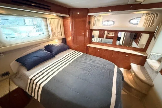 Slide: The Image of Luxurious bedroom interior of 2004 Sea Ray 390 Motor Yacht with elegant wood finishes. - 13