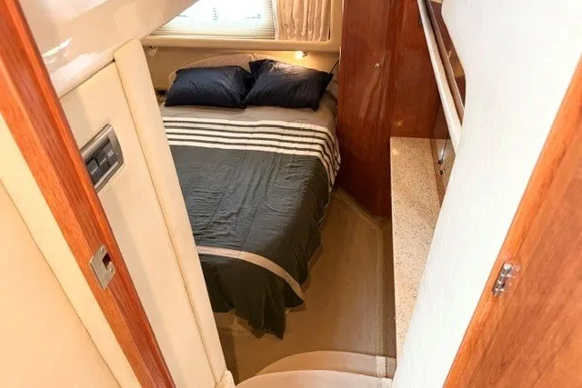 Slide: The Image of 2004 Sea Ray 390 Motor Yacht bedroom with cozy bed and elegant wood finishes. - 12