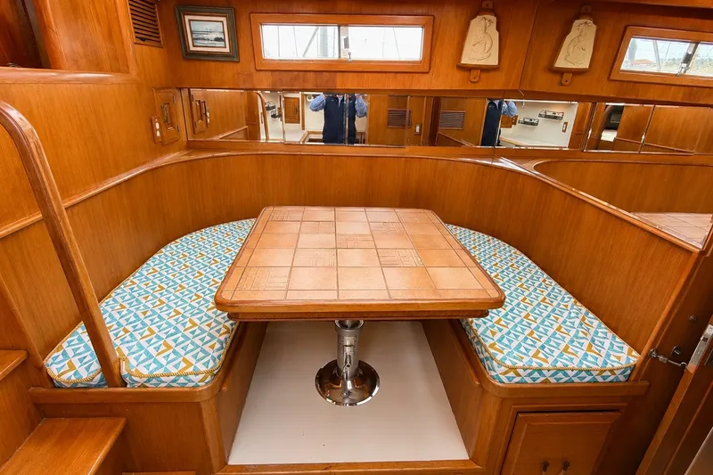 Slide: The Image of 1988 Angel 45 AFT CABIN MV interior with wooden dining area and patterned cushions. - 16