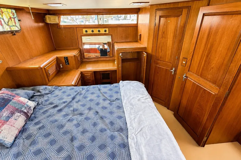 Slide: The Image of 1988 Angel 45 AFT CABIN MV interior with wooden cabinetry and cozy bedding. - 19