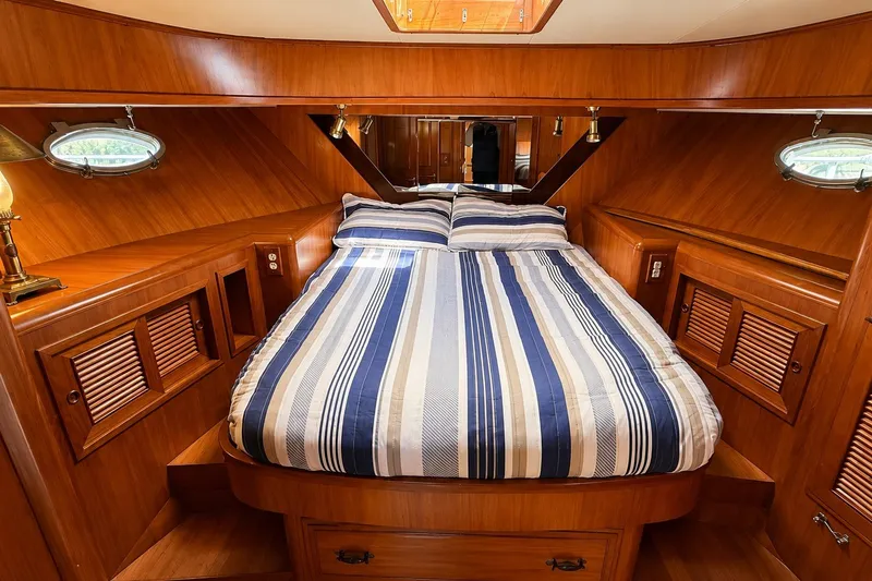 Slide: The Image of Luxurious 1988 Angel 45 AFT CABIN MV bedroom with striped bedding and wooden interior. - 17