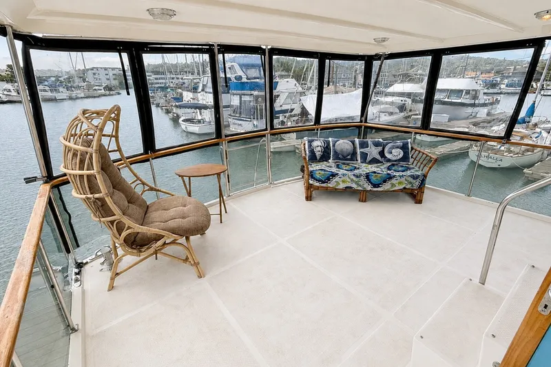 Slide: The Image of Enclosed deck of 1988 Angel 45 AFT CABIN MV with wicker furniture and marina view. - 7