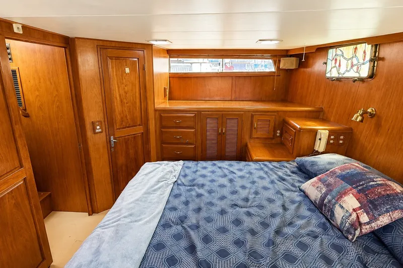 Slide: The Image of Luxurious 1988 Angel 45 AFT CABIN MV bedroom with wood paneling and cozy bedding. - 20