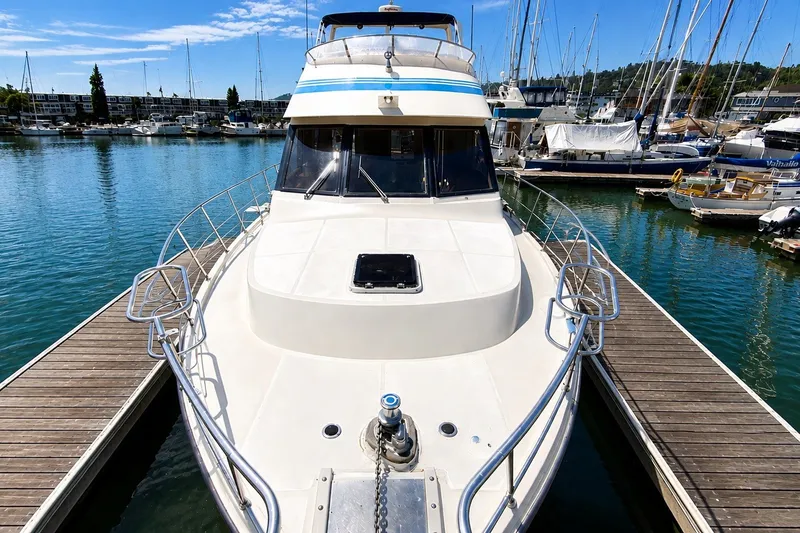 Slide: The Image of 1988 Angel 45 AFT CABIN MV yacht docked in a marina, surrounded by sailboats. - 2