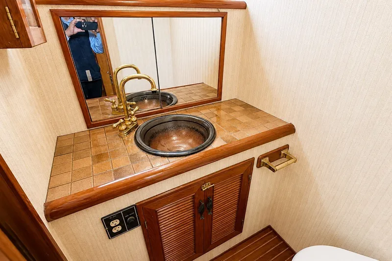Slide: The Image of Elegant 1988 Angel 45 AFT CABIN MV bathroom with brass fixtures and tiled countertop. - 22
