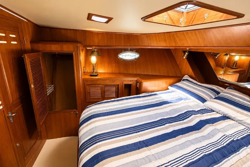 Slide: The Image of Luxurious 1988 Angel 45 AFT CABIN MV bedroom with wood paneling and striped bedding. - 18
