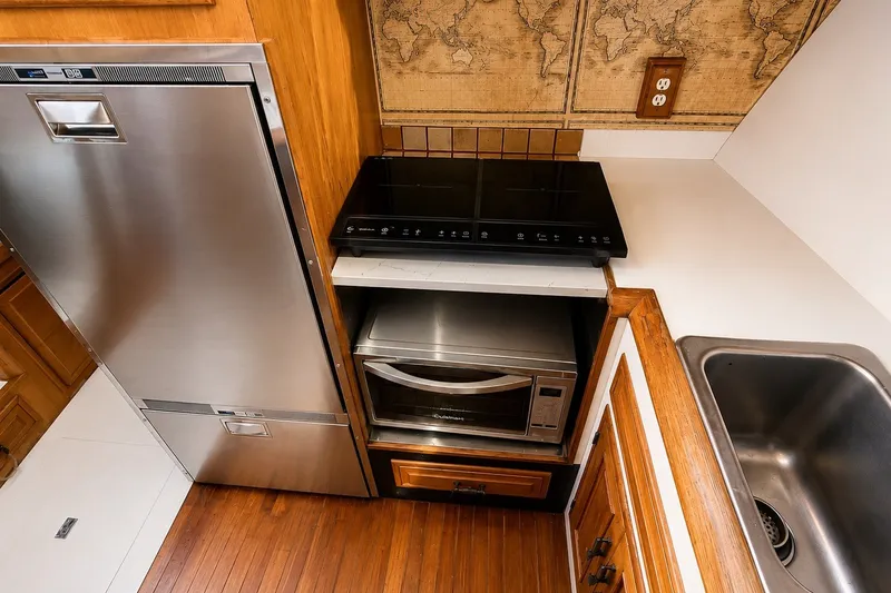 Slide: The Image of Compact kitchen in 1988 Angel 45 AFT CABIN MV with stainless appliances and wood accents. - 15