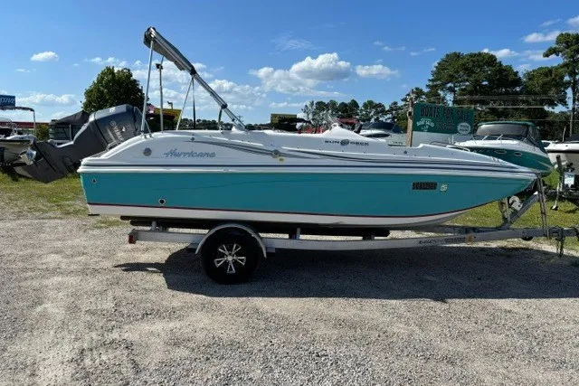 Slide: The Image of 2012 Hurricane SunDeck Sport 188 OB boat on trailer, parked outdoors. - 1