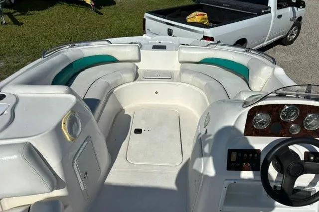 Slide: The Image of 2012 Hurricane SunDeck Sport 188 OB boat interior with seating and dashboard, parked near a white truck. - 5