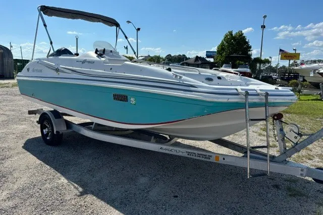 The Image of 2012 Hurricane SunDeck Sport 188 OB boat on trailer, parked outdoors under clear sky. - 0