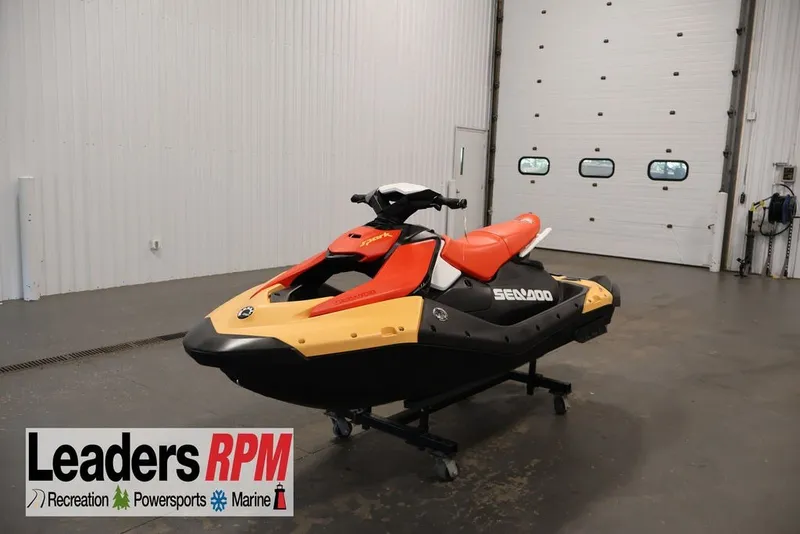 The Image of 2026 Sea-Doo Spark for 3 jet ski in showroom, featuring vibrant red and yellow design. - 2
