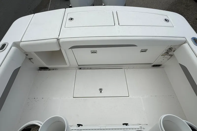 Slide: The Image of 2026 Regulator 28 boat deck with storage compartments and clean white finish. - 18