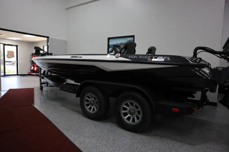 Slide: The Image of 2026 Skeeter ZXR19 SE boat in showroom, black and white design, on trailer. - 12