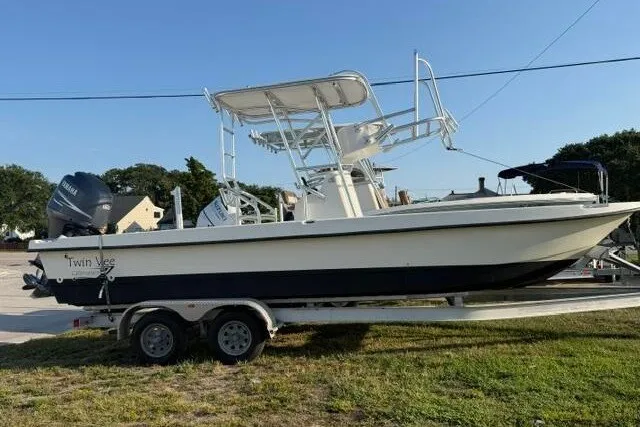 The Image of 2009 Twin Vee 22 BayCat boat on trailer, parked outdoors under clear sky. - 1