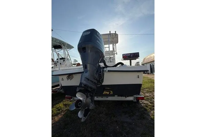 Slide: The Image of 2009 Twin Vee 22 BayCat boat with outboard motor, parked on grass. - 3