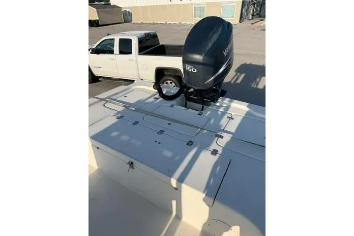 Slide: The Image of 2009 Twin Vee 22 BayCat boat with Yamaha 150 engine, parked near a white pickup truck. - 23