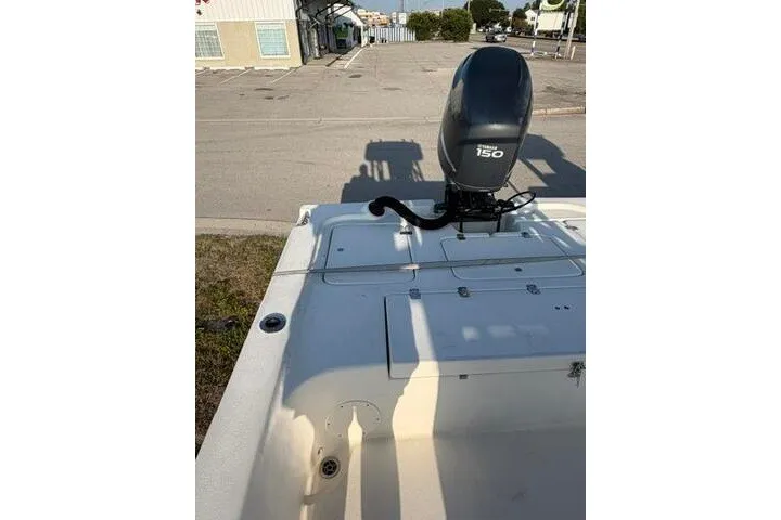Slide: The Image of 2009 Twin Vee 22 BayCat boat with 150 horsepower engine in a parking area. - 19
