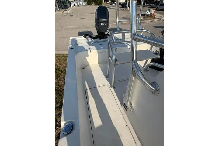 Slide: The Image of 2009 Twin Vee 22 BayCat boat interior with seating and motor, parked outdoors. - 17