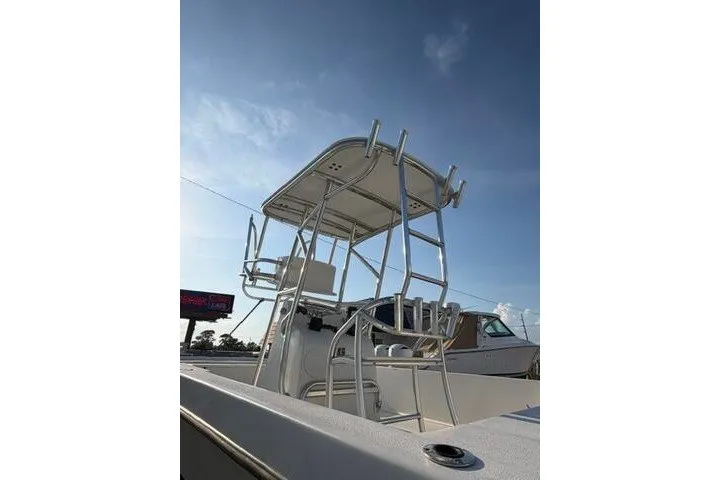 Slide: The Image of 2009 Twin Vee 22 BayCat boat with elevated helm and rod holders under a clear sky. - 6