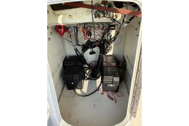 Slide: The Image of 2009 Twin Vee 22 BayCat boat interior showing wiring and battery setup. - 16