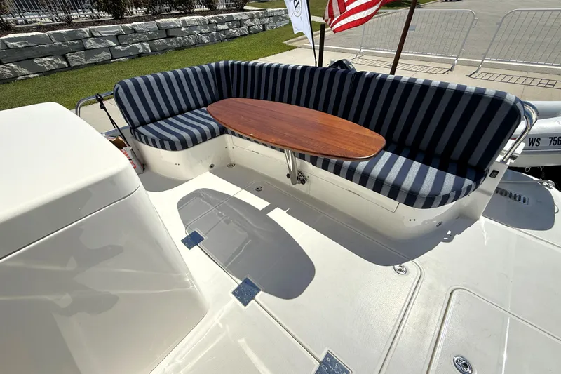 Slide: The Image of 2022 Sabre 48 Salon Express boat with striped seating and wooden table on deck. - 8