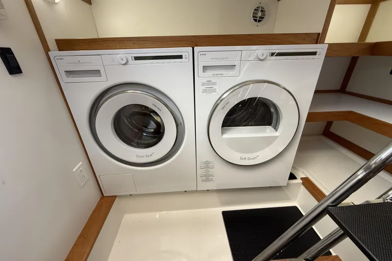 Slide: The Image of Laundry area with washer and dryer inside 2022 Sabre 48 Salon Express yacht. - 43