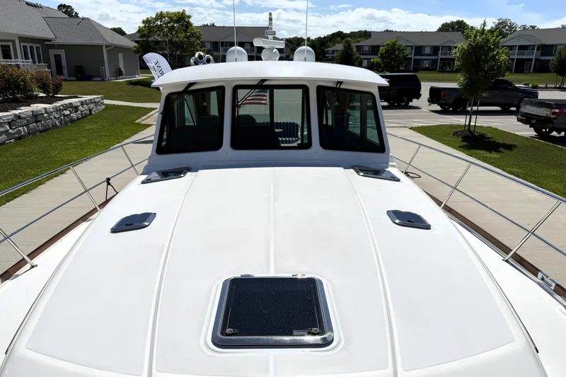 Slide: The Image of 2022 Sabre 48 Salon Express yacht docked in a residential area, showcasing sleek design. - 48